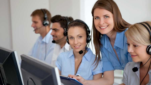 Smiling call center agents with their coach