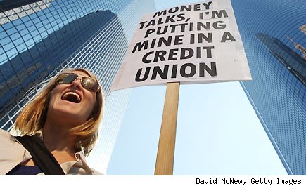 Woman holding a sign that reads Money Talks, I'm Putting Mine in a Credit Union